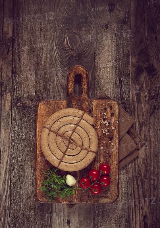 Raw spiral sausages, on a wooden board, top view, no people