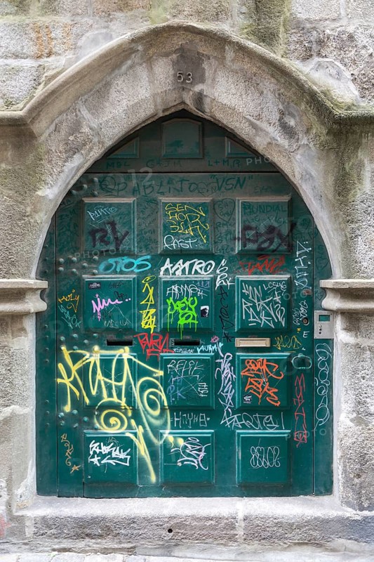 Graffiti tags spray painted on historic door, city of Porto, Portugal