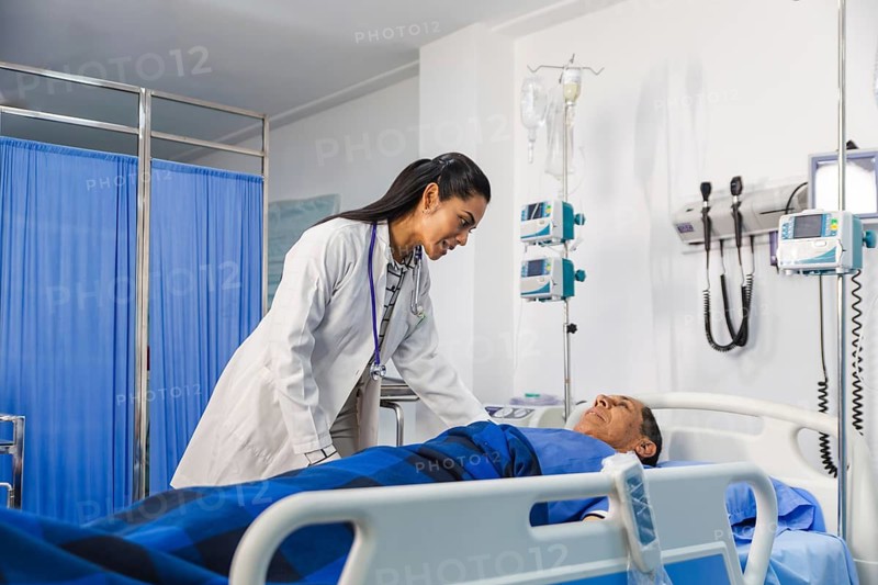 A compassionate female doctor attentively examines an elder patient in a hospital room, highlighting empathy and professionalism in healthcare settings, with medical equipment nearby