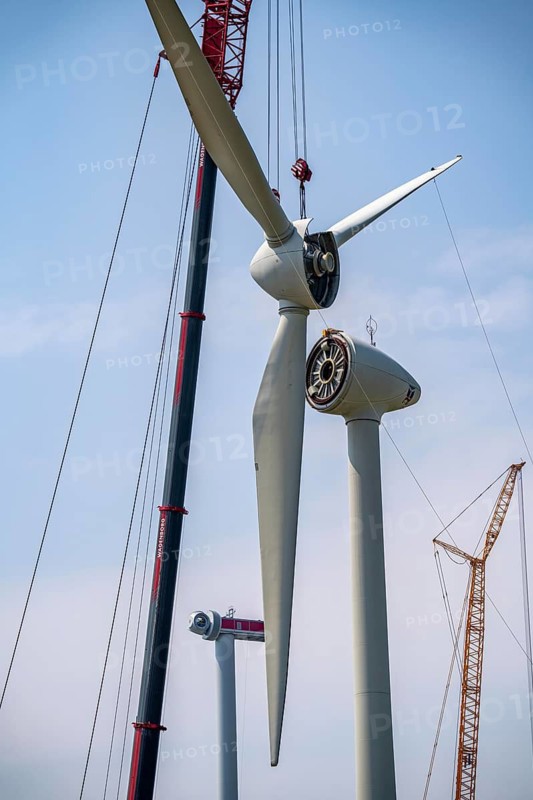 Dismantling of a wind power plant in a wind farm near Issum, 9 older wind turbines from the manufacturer Enercon (model series E-58), front, blades being dismantled, were in operation for over two decades, will be replaced by a total of four Enercon E-160 turbines, rear, assembly of the first blade, with a total output of 22 megawatts, Lower Rhine, North Rhine-Westphalia, Germany