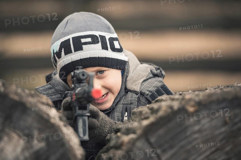 Five years old boy playing with a rifle toy