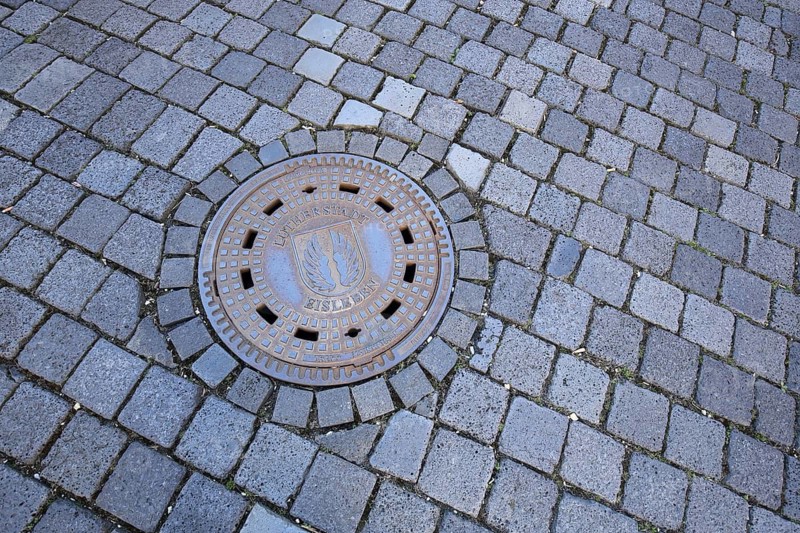 Round manhole cover and paving stones, floor, Luther city Eisleben, Harz, Saxony-Anhalt, Germany