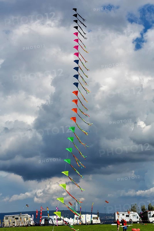 Colourful, strung kites flying in the sky, garland, kite festival in Vinsebeck, mobile homes, Steinheim, Eggegebirge and Southern Teutoburg Forest nature park Park, Weserbergland, North Rhine-Westphalia, Germany