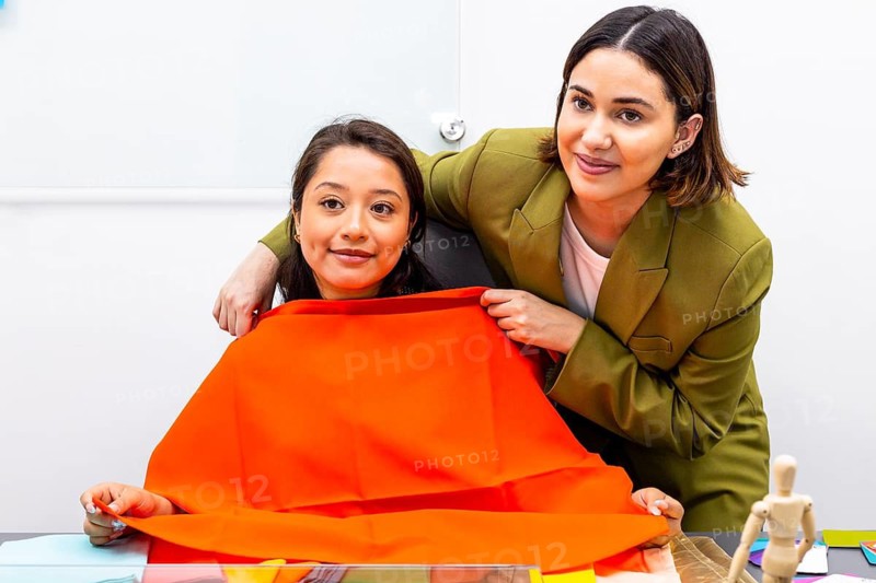 A professional image consultant assesses a woman color palette using vibrant fabric swatches. This consultation aims to enhance personal style and confidence through expert guidance