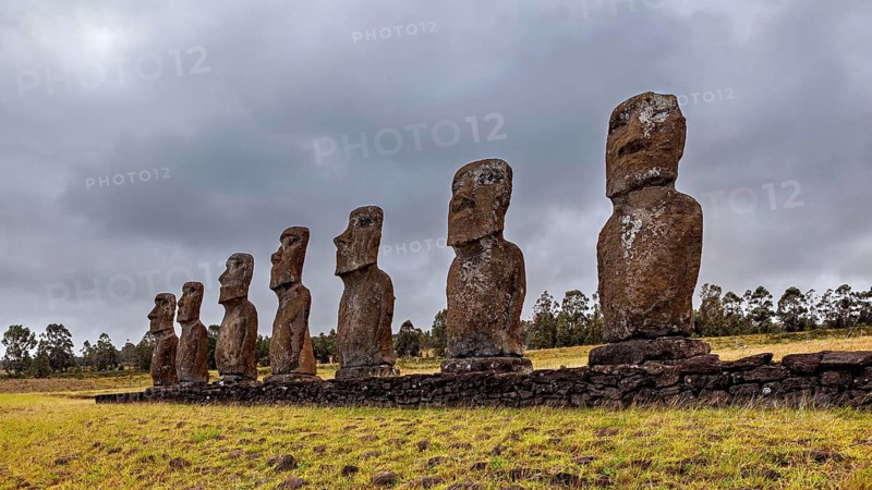A series of Moai statues on Easter Island under a cloudy sky, The Moai statues on Easter Island in the Pacific Ocean