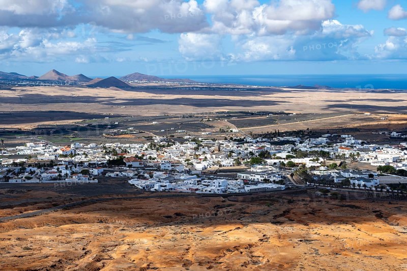 View of town, white houses of Teguise with church tower in dry volcanic landscape, Lanzarote, Canary Islands, Spain