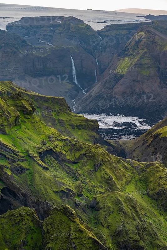 Moss-covered mountains at sunset, waterfalls on a cliff at Myrdalsjökull glacier, Pakgil, Iceland