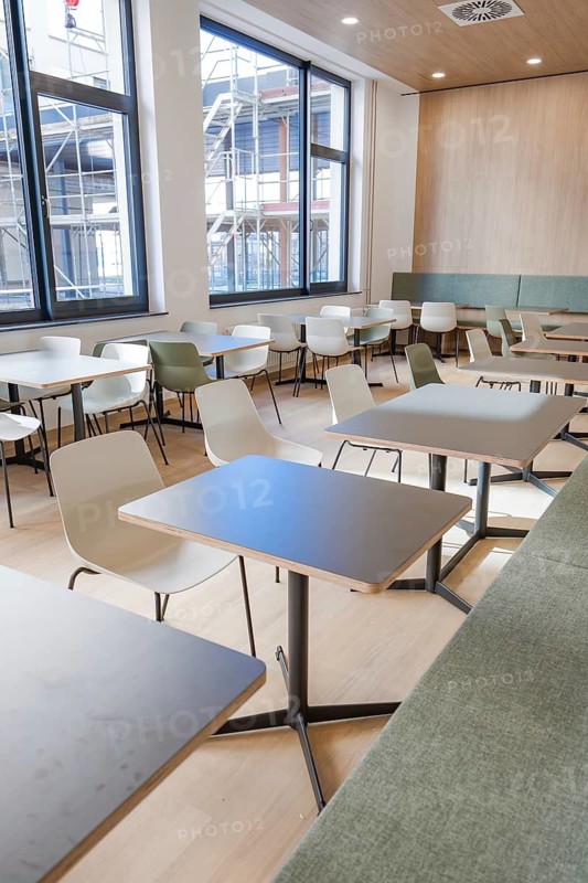A modern, bright canteen with tables and chairs and large windows reflecting a minimalistic design, cafeteria, new hospital Calw, Germany