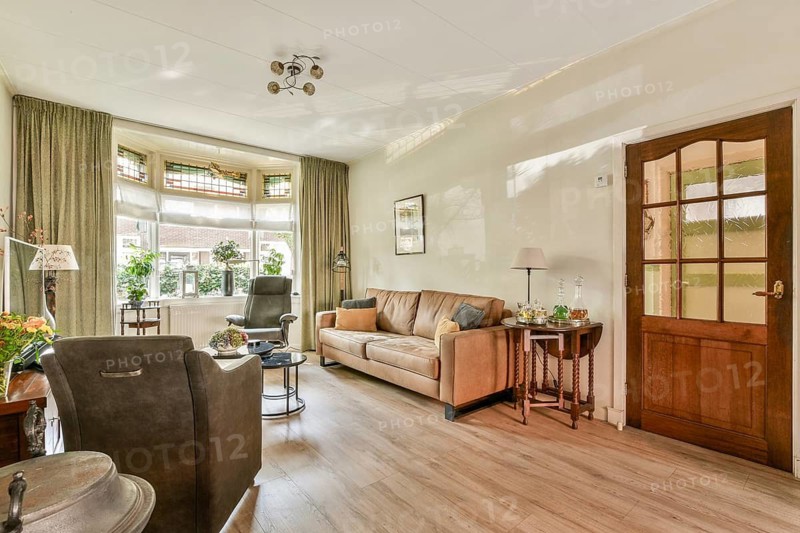 A comfortable living room designed for relaxation, featuring soft furnishings, natural light, and tasteful decor, creating a warm atmosphere