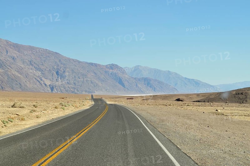 Straight road through dry desert landscape with mountain views, Death Valley National Park, Mojave Desert, California, Nevada, USA