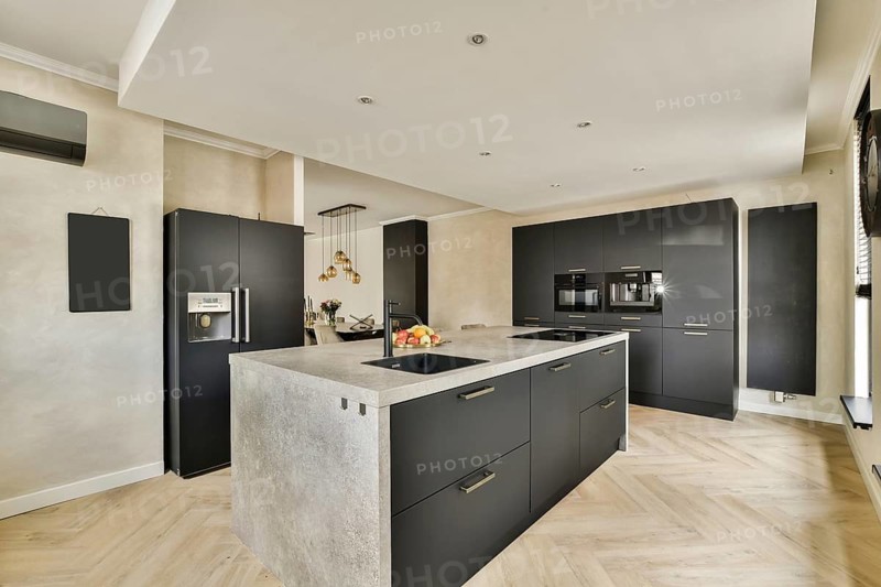 A stylish modern kitchen featuring sleek cabinetry, sophisticated appliances, and elegant lighting fixtures, creating a contemporary ambiance