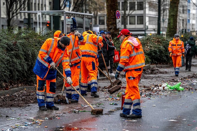 Sweep on Rose Monday in Düsseldorf, the municipal utilities clean up after the train, confetti, camels, trash, employees of AWISTA, Society for Waste Management and City Cleaning, central disposal and urban cleaning companies in Düsseldorf, clean the train's path with their street cleaning machines, North Rhine-Westphalia, Germany