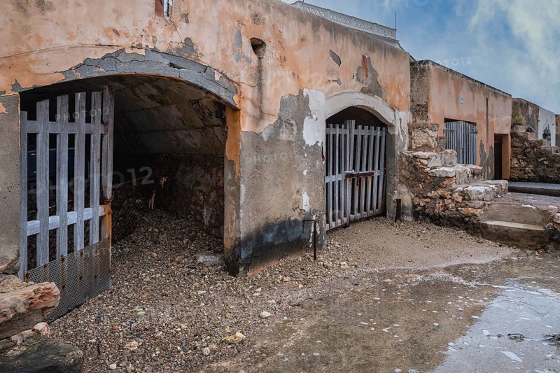 Old and dilapidated boat shelters that are not being used, old port area in Portocolom on the east coast of Majorca, Spain