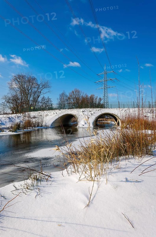Bottrop, North Rhine-Westphalia, Germany - Sunny winter landscape in the Ruhr area, ice and snow on the renaturalised Boye, the small river is being renaturalised, is being transformed into a near-natural body of water, the Boye is part of the Emscher river system and thus part of the Emscher conversion, was previously an open, above-ground wastewater canal, mixed water canal with surface water and wastewater