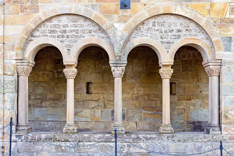 Three Romanesque arches with columns on a rustic stone wall, showing medieval architectural details, The arcades of the palace of Wartburg Castle near Eisenach in Thuringia