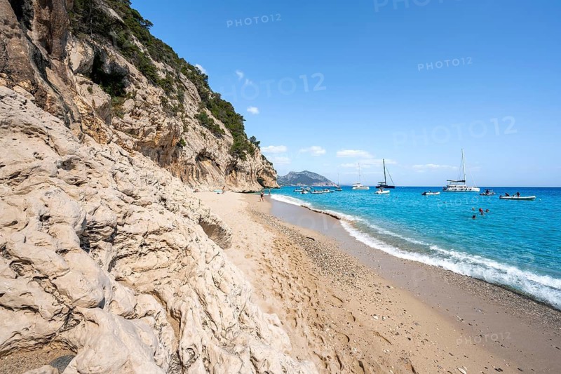 Sandy beach beach and steep cliffs at Cala Luna, Golfo di Orosei, Baunei, Sardinia, Italy
