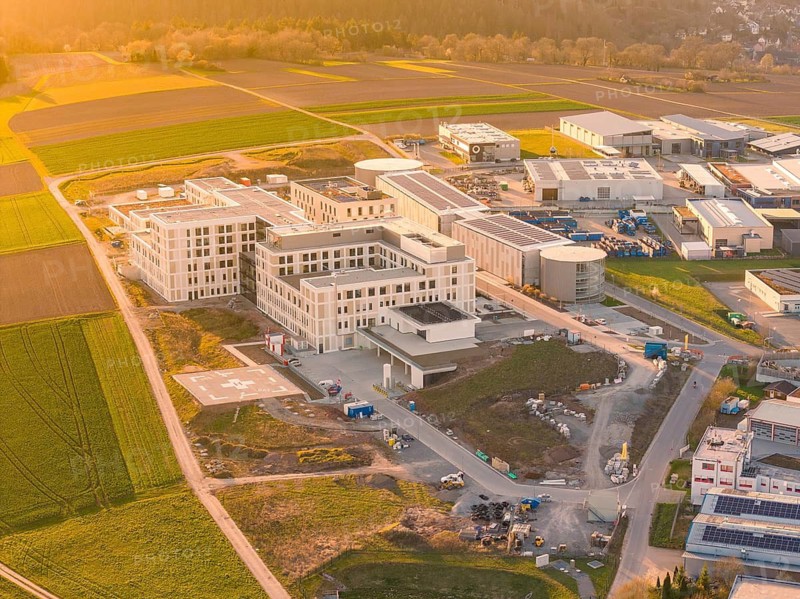 A modern building complex in a rural building area, taken from the air at sunset, new hospital at the Verbund Südwest Clinic, Calw, Germany