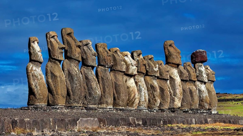 Moai statue row against a dramatic blue sky on Easter Island, The Moai statues on Easter Island in the Pacific Ocean