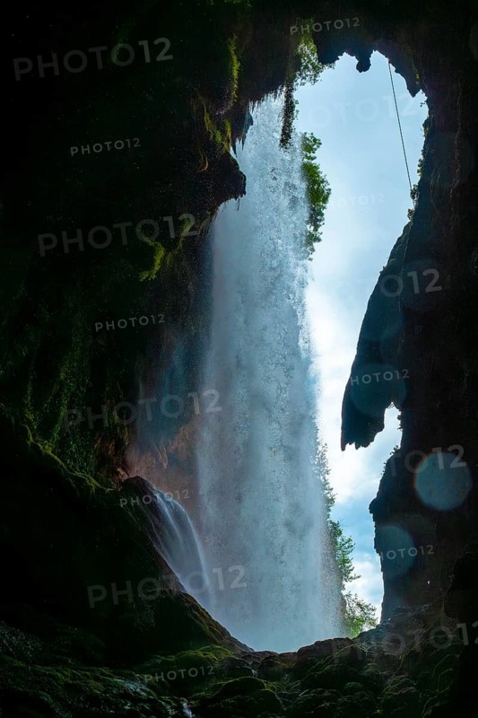 Inside the waterfall in the Iris Grotto at the Cola de Caballo Waterfall in the Monasterio de Piedra Natural Park, Aragon
