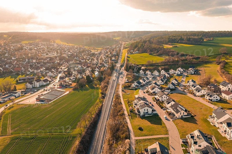 View of a village with railroad tracks and agricultural land at sunset, Hermann Hesse Railway, Ostelsheim, Calw district, Germany