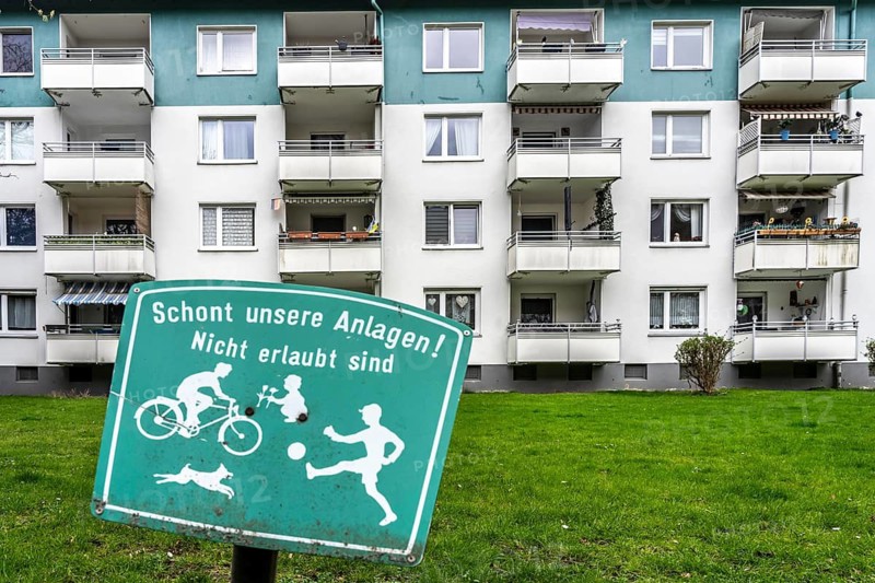 Residential development, rental apartments, prohibition sign on the lawn, meadow in front of the apartments, prohibition of various games, ball games, bicycle, dogs, playing in green areas, no children's playground, North Rhine-Westphalia, Germany