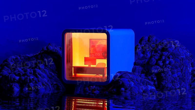 A contemporary workspace sits alone on rocky terrain, bathed in warm light, surrounded by a tranquil landscape under a night sky