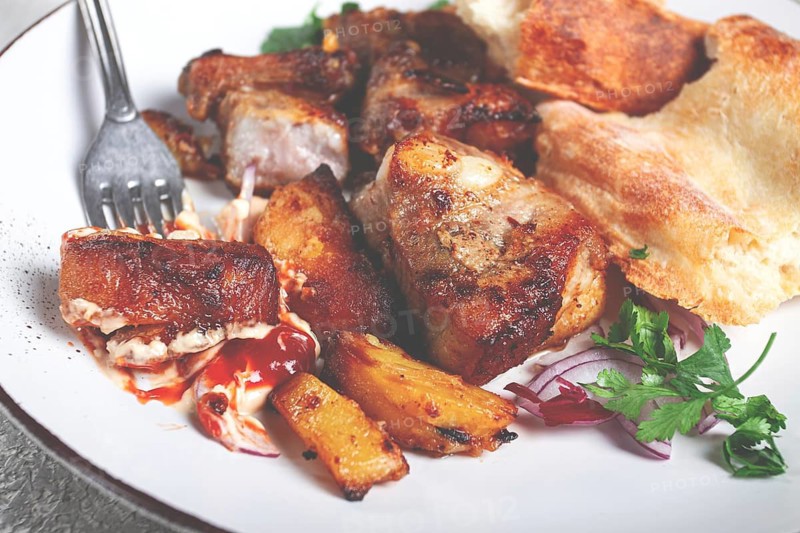 A plate with leftover pork kebab, with bread, on a white plate, close-up, there are no people