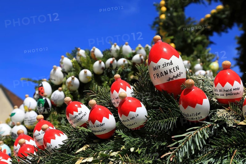 Easter fountain, Franconian Switzerland, Heiligenstadt, Bamberg district, Upper Franconia, Bavaria, Germany, detail with painted and inscribed eggs with Franconian expressions, close-up of Easter eggs with Franconian sayings on green branches