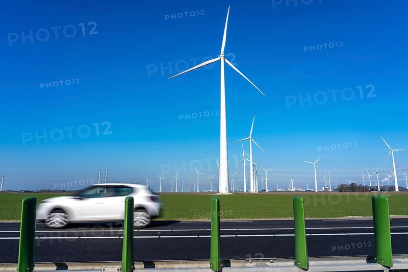 Wind farm in the north of the Netherlands, near Eemshaven, energy center, in addition to wind energy, there are coal and gas power plants and various energy infrastructure facilities, country road, Netherlands