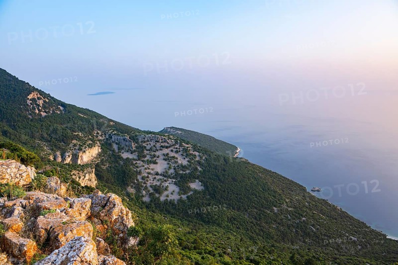 View from Lubenice across the sea with coastal landscape and bays on a sunny day at sunset on the island of Cres, Croatia