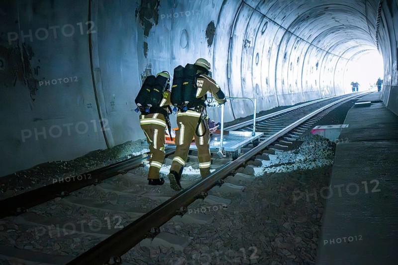 Firefighters move along the rails in the tunnel with equipment, fire brigade exercise on the Hermann Hesse railway, Ostelsheim, Germany