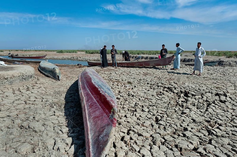 Al Chibayish, Iraq. November 1st 2018 Boats pulled up on dried cracked earth during a drought in the Southern Marshes of Iraq. Climate change and political instability causing a crisis for local fishermen and farmers