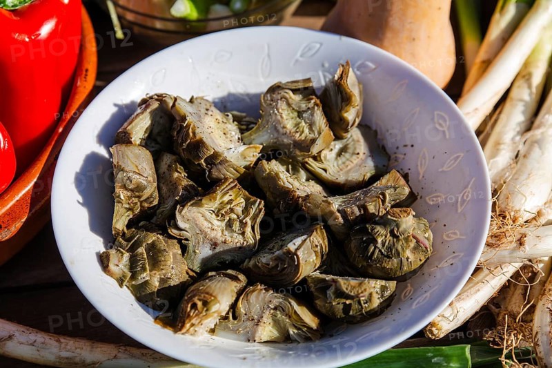 Fresh artichokes and seasonal vegetables, emphasizing Catalan culinary traditions. This farm-to-table scene highlights the vibrant produce essential to Catalan cuisine