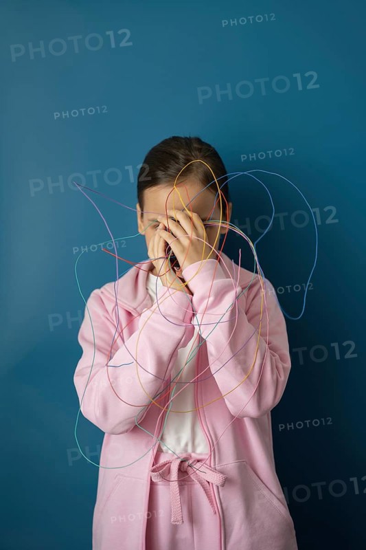A child in a pink outfit stands against a blue background, tangled in colorful wires, symbolizing the complex impact of the internet and technology on childhood development