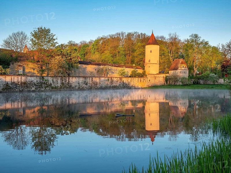 Digestive tower with park guard house on the city wall in morning light, reflection in the Rothenburg pond, Romantic Road, Dinkelsbühl, Middle Franconia, Bavaria, Germany