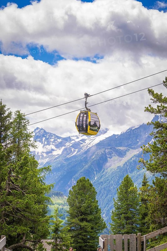 Cable car over the Alps, with snow-covered mountains and forest in the background, Penken, Zillertal. Austria