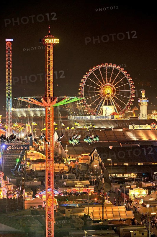 View over the Wies'n at night with illuminated carousel, Ferris wheel, stalls, beer tents and rides, Oktoberfest, Wiesn, Munich, Upper Bavaria, Bavaria, Germany