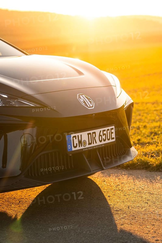 Black car from the front with sunset in the background in a rural setting, e-car sharing vehicle from Deer Mobility, Gechingen, Black Forest, Germany