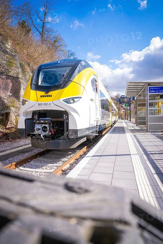 Close-up of a modern train on a platform under blue sky and clouds, Hermann Hesse Bahn, ZOB, Calw, Germany