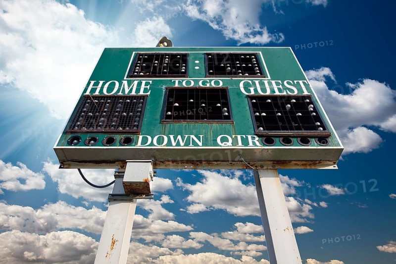 HIgh School Scoreboard Over Blue Sky with Clouds and Sun Rays