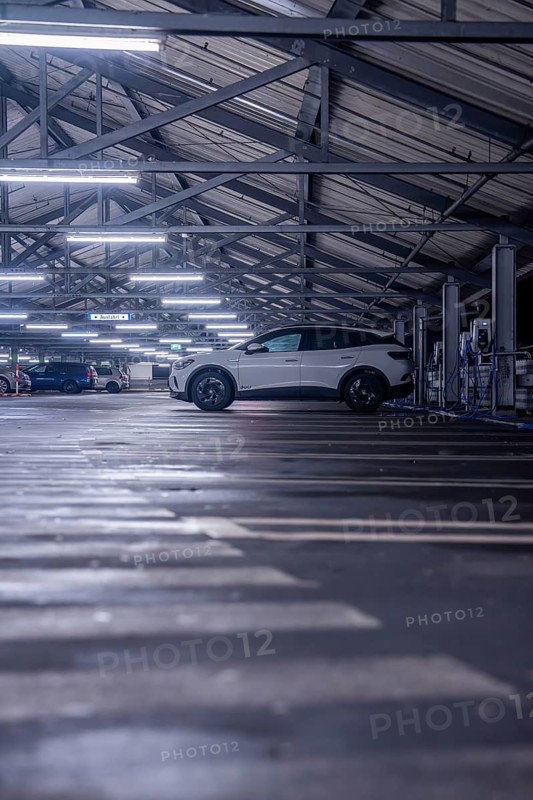 An illuminated car park with a parked electric car on one parking level, Kaufland Calw multi-storey car park, Calw district, Black Forest, Germany