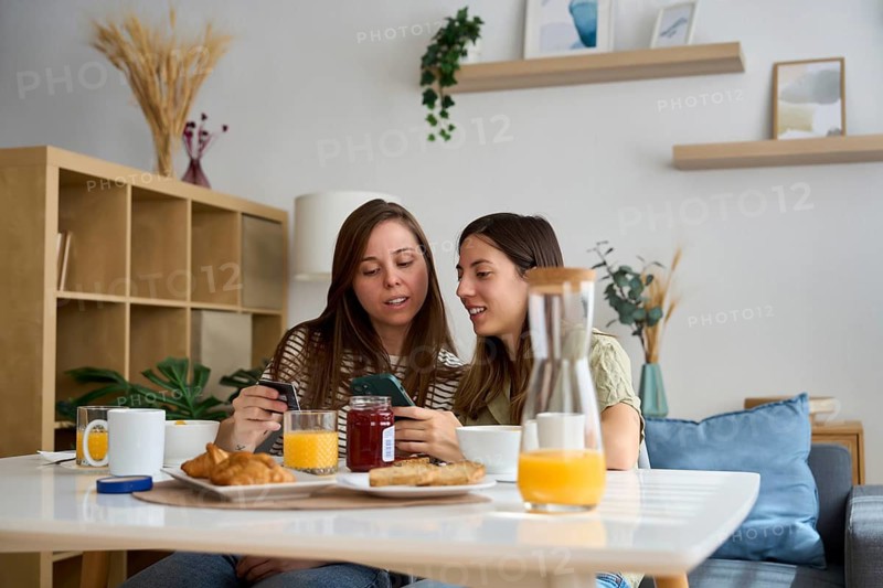 A lesbian couple enjoys a cozy breakfast at home, sharing a moment of connection and joy The image captures a sense of warmth, love, and inclusivity