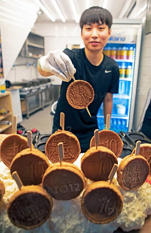 Korean man, 26, showing a mozzarella pancake, Gwangjang market, traditional street market in Jongno-gu, Seoul, South Korea