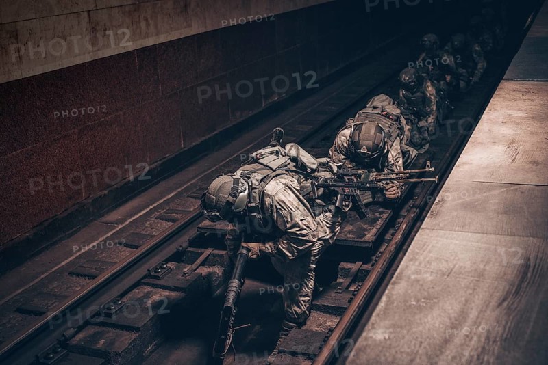 Image of a SWAT group sneaking along the rails in the subway. Special operation concept.