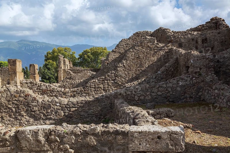 Old stone wall structures of varying heights and remnants of residential buildings at the ancient ruins of Pompeii, Campania region, Italy