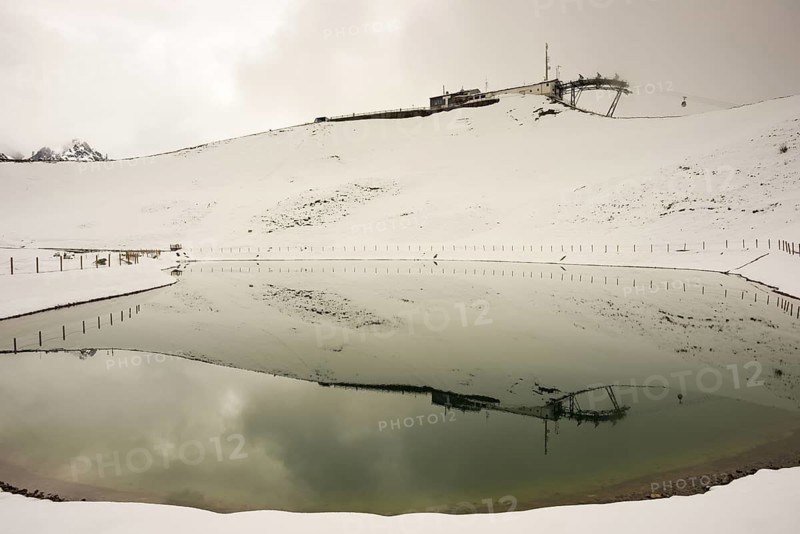 After snowfall in May: Riezler Alpsee, an artificial lake, snow pond, feeds the snow cannons that completely cover the slopes of the Fellhorn and Kanzelwand cable cars with snow, Allgäu Alps, Vorarlberg, Austria