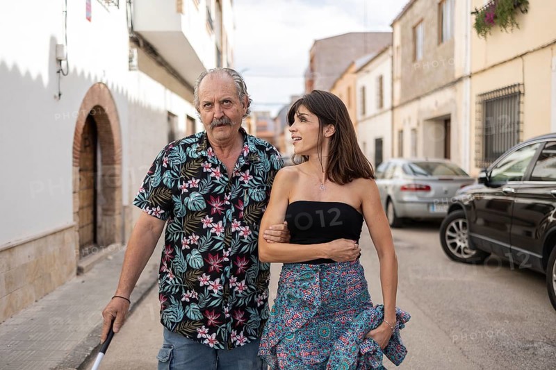 Blind father with a cane walking through the town with the support of his daughter, conveying a sense of companionship and accessibility