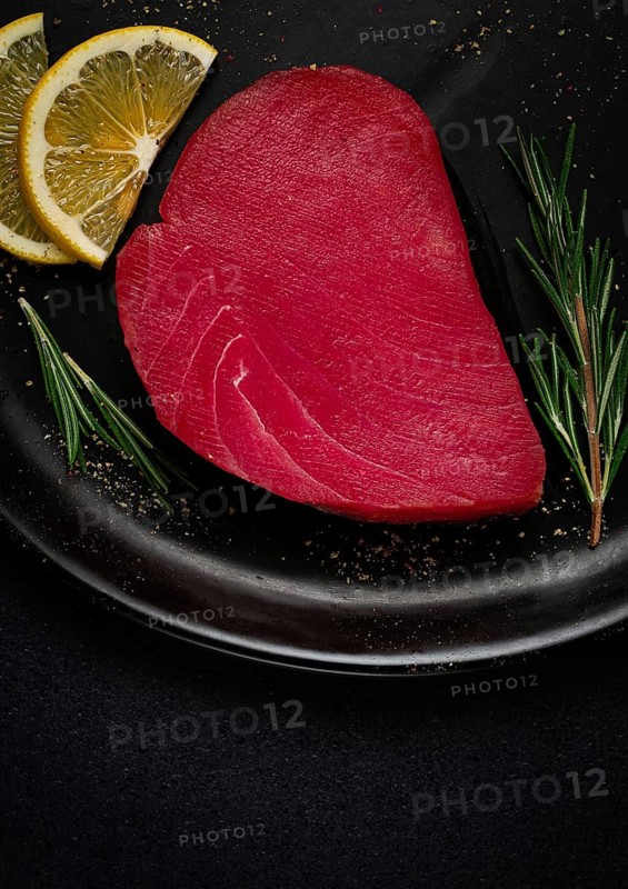 Fresh red tuna fillet, for steak, raw, top view, on a black plate, no people
