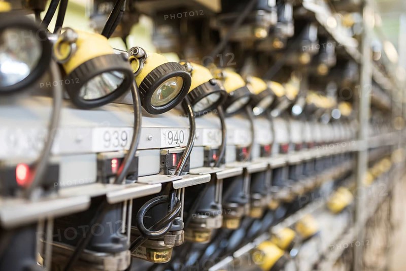 Mining head lamps on the shelves in the mine's lamp room
