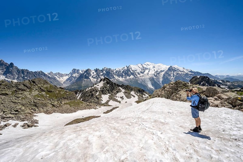 Mountaineer taking a photo, crossing a snowfield, mountain landscape with mountain peak Mont Blanc, Mont Blanc massif, Aiguilles Rouges, Chamonix-Mont-Blanc, Haute-Savoie, France